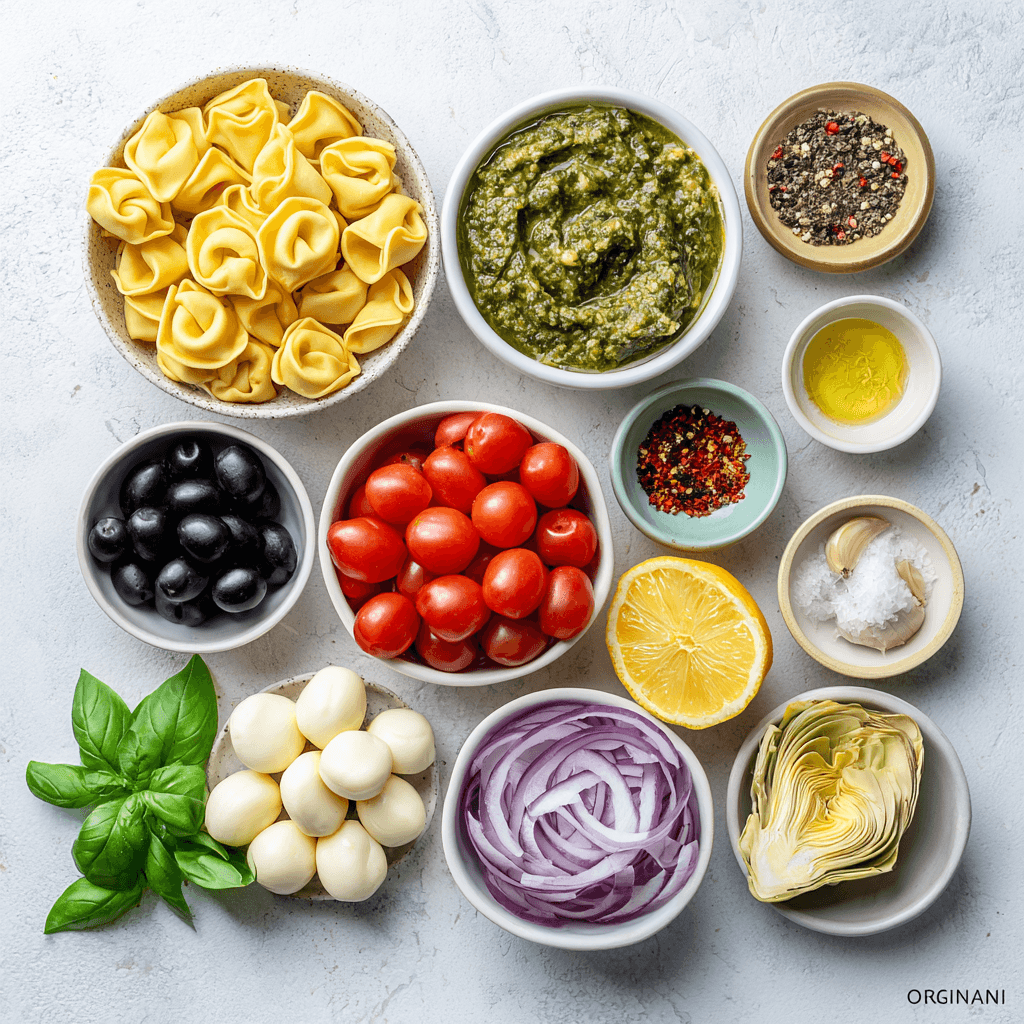 Ingredients for pesto tortellini pasta salad including tortellini, pesto, tomatoes, and cheese