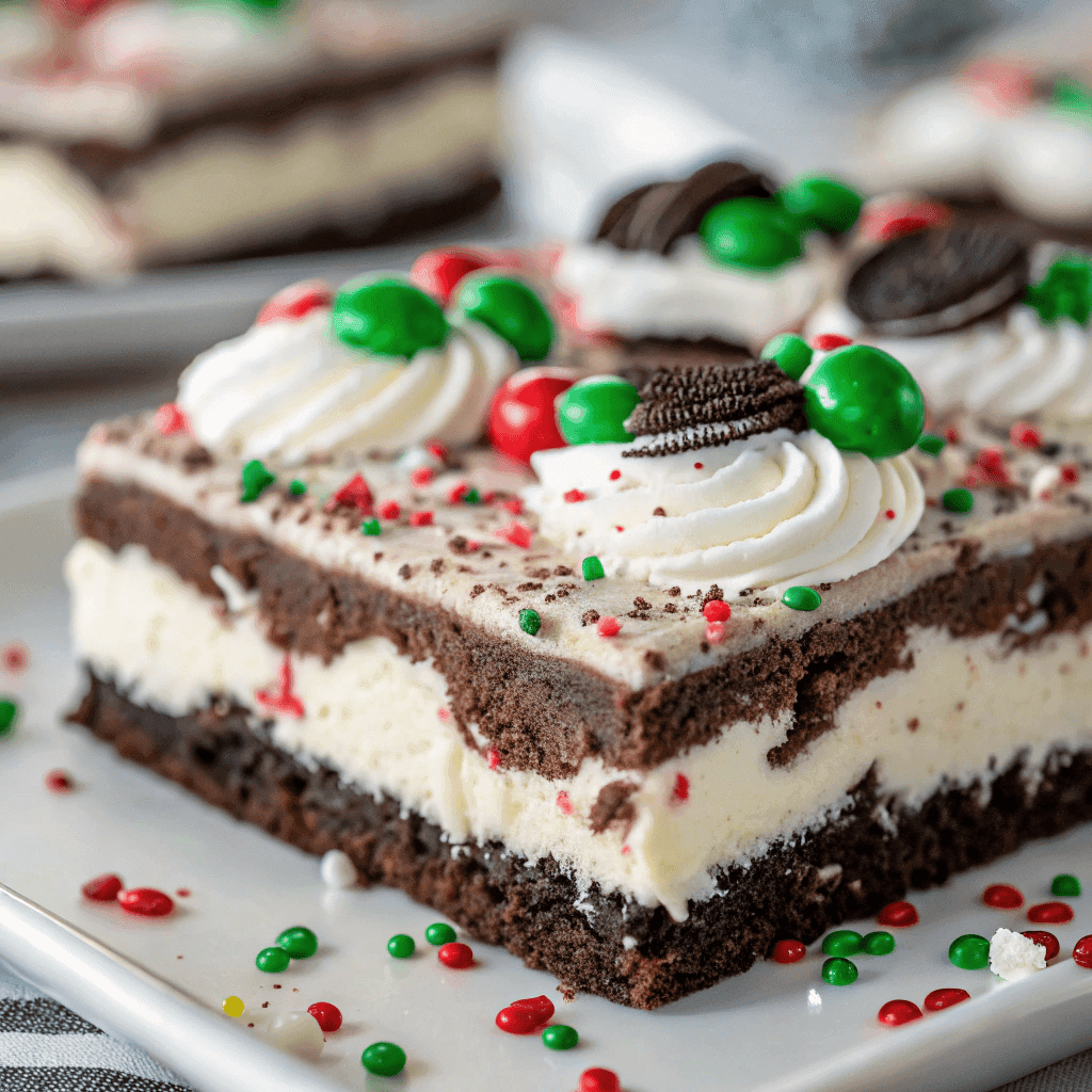 Macro shot showing detailed layers of Oreo crust, cream, and holiday candies in Christmas Oreo lasagna.