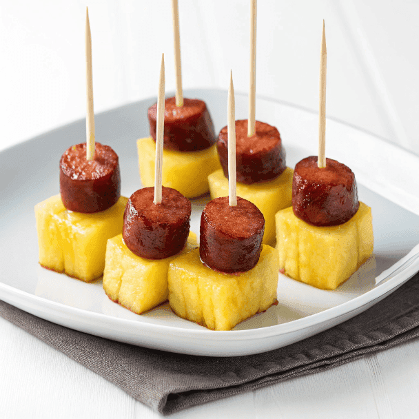 Kielbasa sausage and pineapple appetizer bites served on a white plate